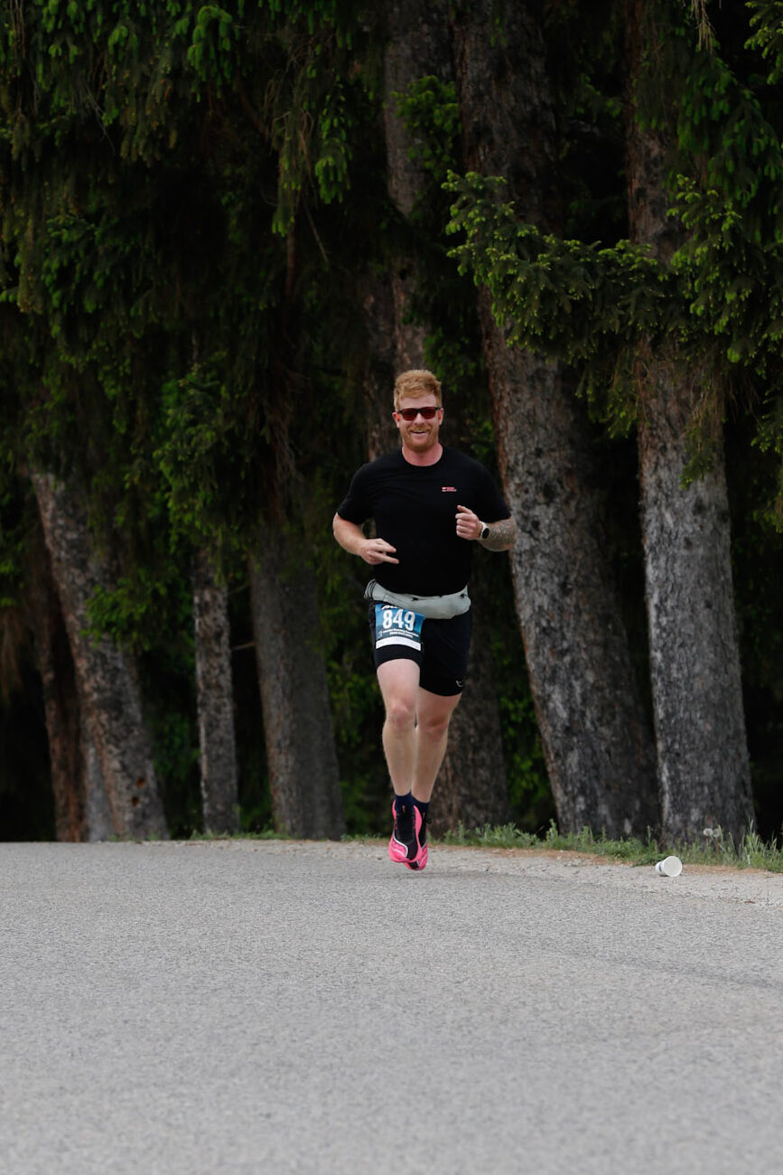 General Manager, Brandan, competing in a race. Pictured on a BC roadway along a coniferous tree forest.