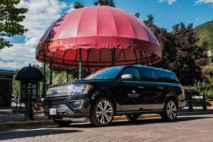 Revelstoke Transfers luxury SUV shuttling passengers around downtown Revelstoke in summer