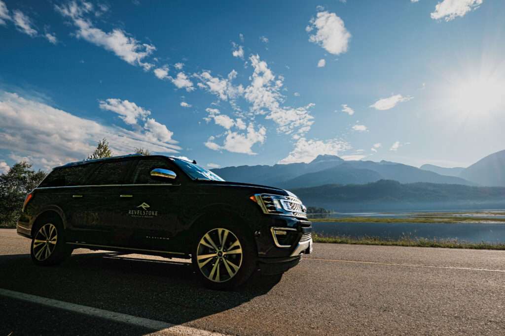 Revelstoke Transfers luxury SUV shuttling passengers around downtown Revelstoke in summer